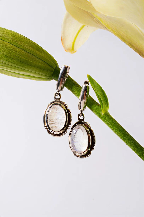 Earrings displayed beside a green stem